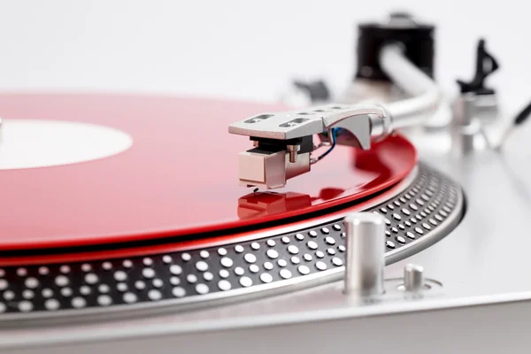 Turntable needle on a red plate