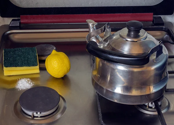 Cleaning a gas stove with baking soda and lemon.