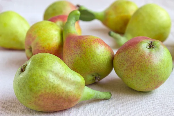 Still life - bright fruit on light fabric. Fancy Pears - closeup.