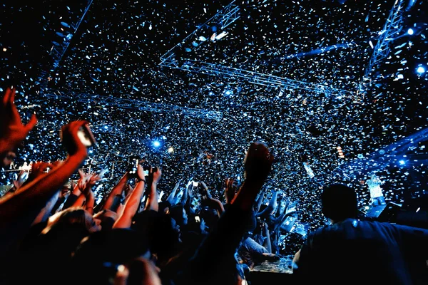 Night club party event concert with crowd of people and confetti at the stage