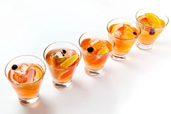 Five orange cocktail drinks with ice and olives isolated on white background