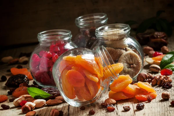 Dried apricots in a glass jar on a dark wooden background