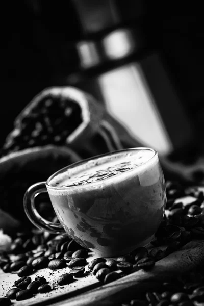 Coffee with milk, coffee maker, coffee beans, dark toned image