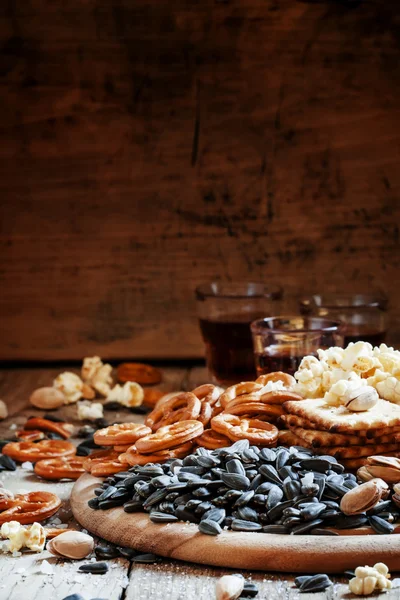 Sunflower seeds salted and roasted with a plate of snacks