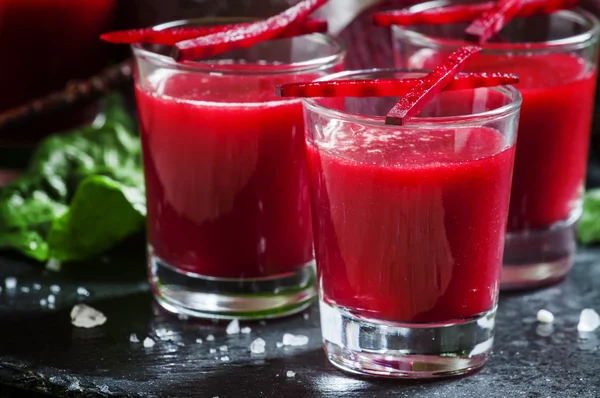 Beetroot juice in glasses on a dark background