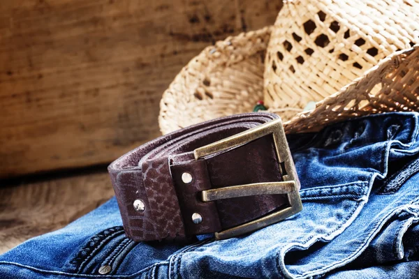 Jeans, straw hat, leather belt - women\'s clothes in cowboy country style