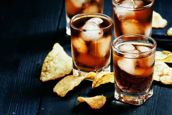 Cold Cola with ice in glasses and potato chips
