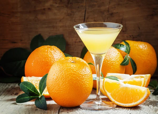 Yellow cocktail with orange juice in a martini glass