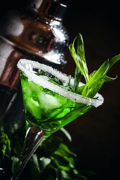 Green cocktail with tarragon and ice in martini glass