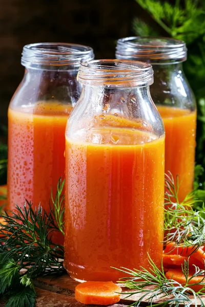 Freshly squeezed juice of carrots in glass bottles