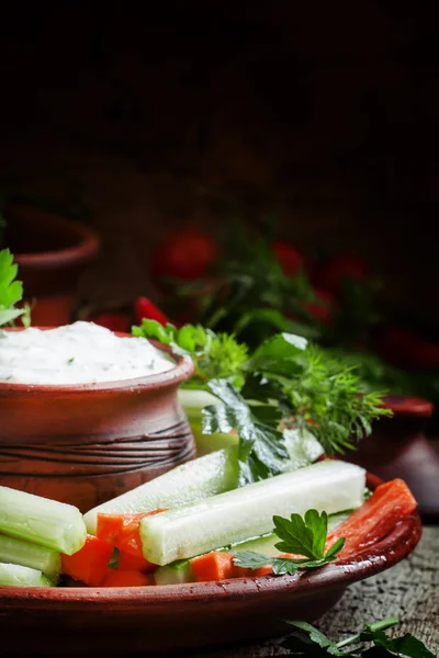 Healthy snacks: cucumber sticks, celery and carrots with ranch dressing