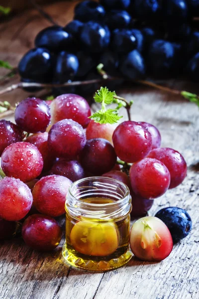 Essential oil of grape seeds and a fresh bunch of grapes