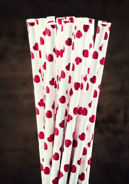 Background with white cocktail straws with red hearts