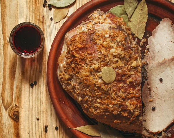 Baked ham with spices on a clay plate