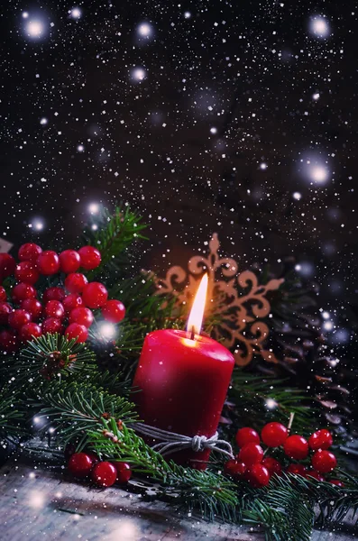 Christmas or New Year\'s dark composition with burning red candle