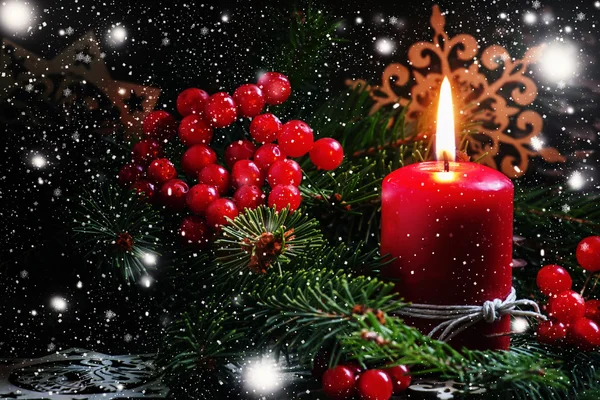 Christmas or New Year\'s dark composition with burning red candle