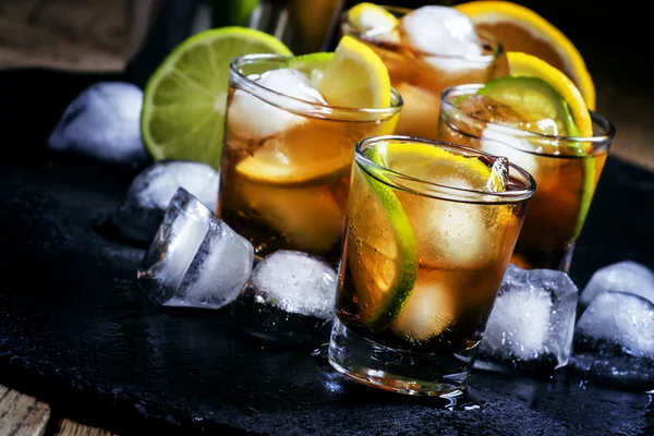 Alcoholic cocktail rum cola with ice, lime, lemon, cola and white rum