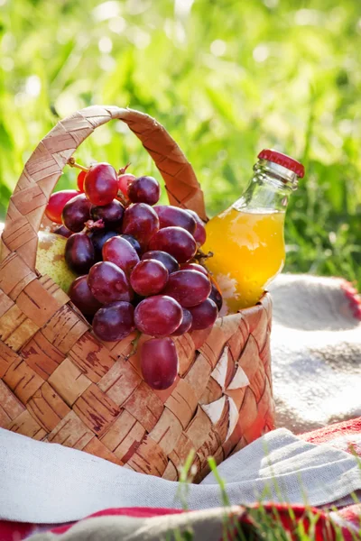 Wicker picnic basket with fruits and drinks
