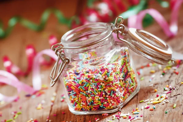 Colorful sugar strew pearls in a glass jar
