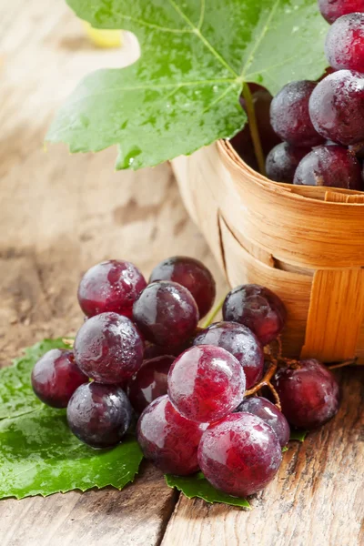 Purple round ripe grapes in a wicker basket