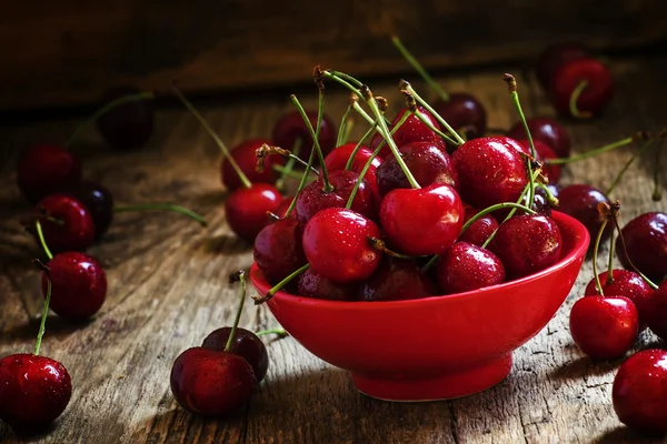 Red sweet cherries in a red bowl