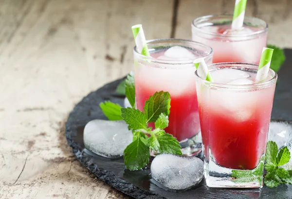 Cold red cocktail with ice and mint