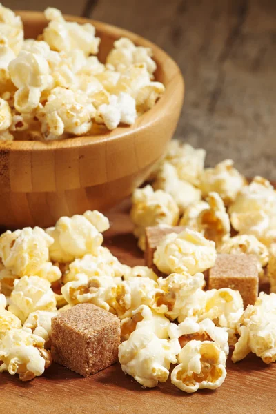 Caramel popcorn poured from a wooden bowl