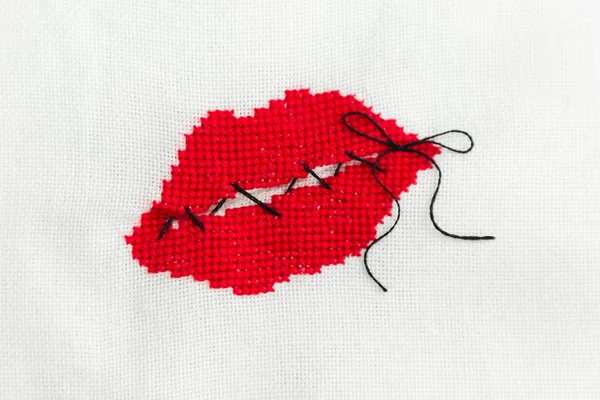 Red embroidered lips that are sewn with black thread.