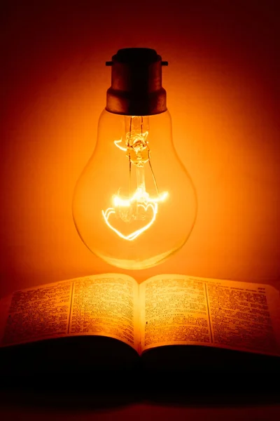 Light bulb turned on above the holy bible
