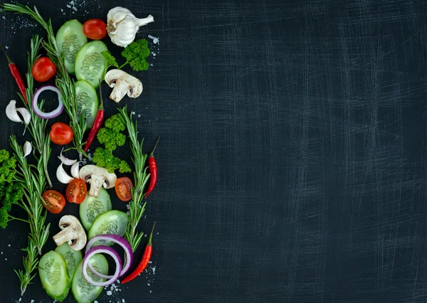 Top view of fresh vegetables and spices on dark wooden background with space for text. Vegetarian food, health or cooking concept.