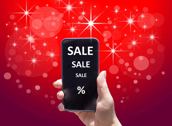 The phone with text SALE in female hand on the red background
