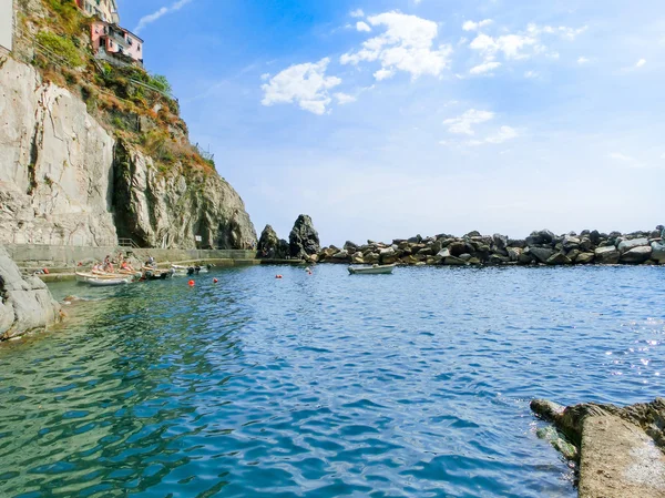 Manarola, Cinque Terre, Italy - September 09, 2015: The boats near a rock at Mediterranean sea