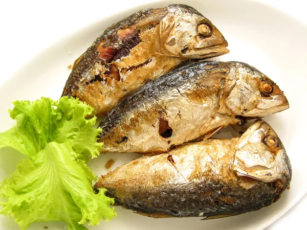 Three fried mackerel put in the dish at kitchen of restaurant