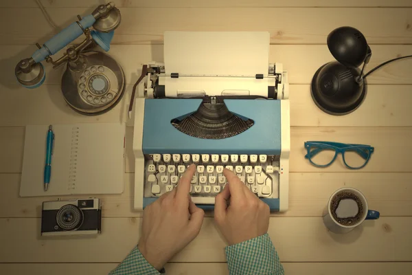 Hands on typewriter at the office desk. Flat lay.