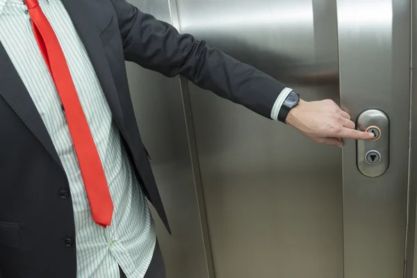 Businessman pressing elevator up button