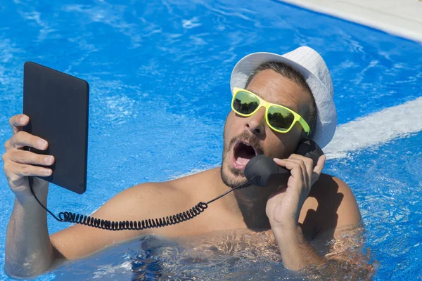 Guy having a call from a swimming pool