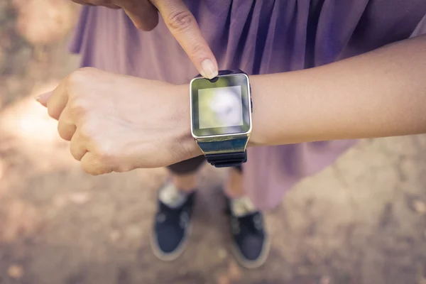 Female hand pressing the button on smart watch