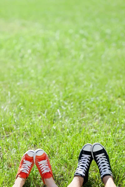 Feet in sneakers on grass