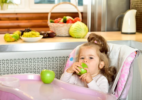 Baby girl eating green apple