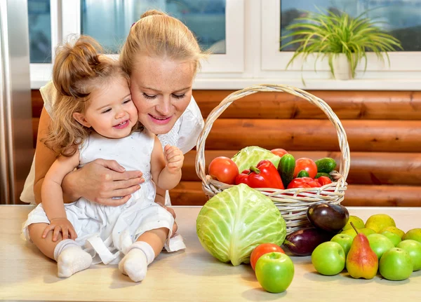Happy young mother with a baby in the kitchen