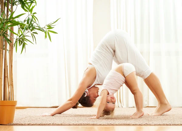 Mother and daughter doing yoga exercises