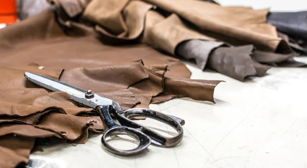 Skilled leather manufacture worker cutting some samples