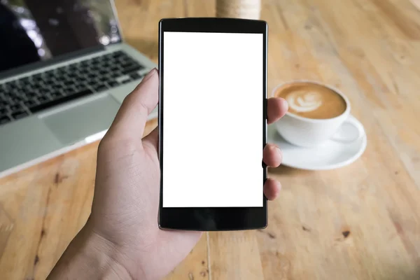 Close up of a man using smart phone with blank mobile and cup of coffee .Smart phone with blank screen and can be add your texts or others on smart phone.