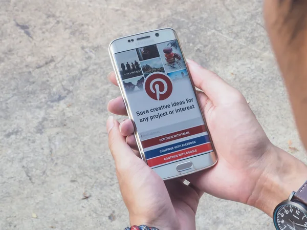 CHIANG MAI,THAILAND - APR 26,2016 : Man holding a samsung galaxy s6 edge with social Internet service Pinterest on the screen. Pinterest is pinboard that allows people to pin their interesting things.