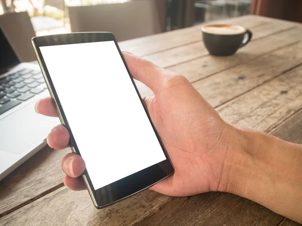 Close up of a woman using smart phone with blank mobile and cup of coffee .Smart phone with blank screen and can be add your texts or others on smart phone.