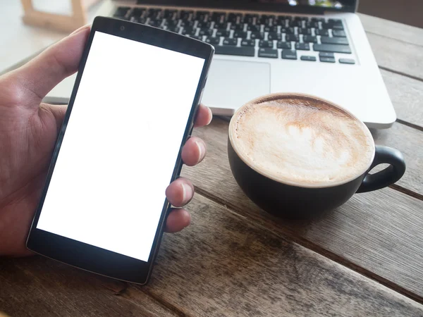 Close up of a woman using smart phone with blank mobile and cup of coffee .Smart phone with blank screen and can be add your texts or others on smart phone.