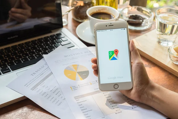 CHIANG MAI,THAILAND - MAY 09: Woman hand holding IPHONE 6 PLUS with Google Maps application o. Google Maps is a service that provides information about geographical regions and sites around the world.