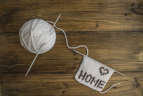 The word home associated made of wool and a ball of white wool