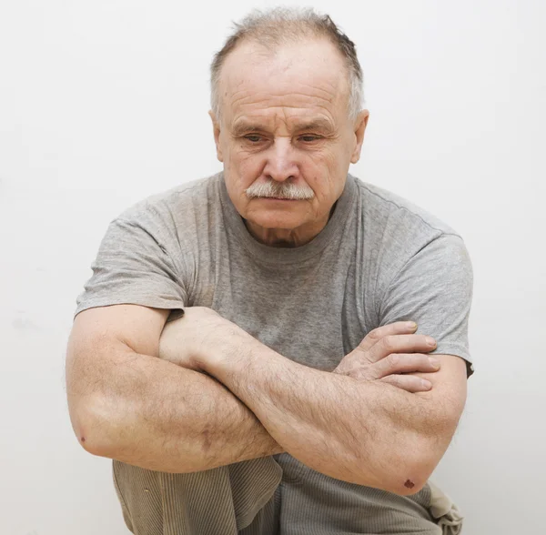 Portrait of the sitting sad elderly man