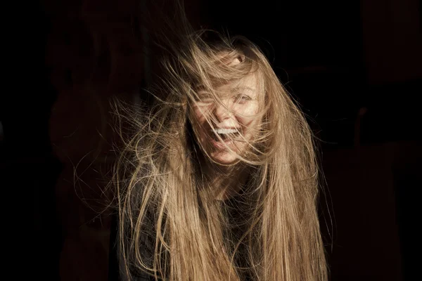 The laughing young woman with the developing hair on a black bac